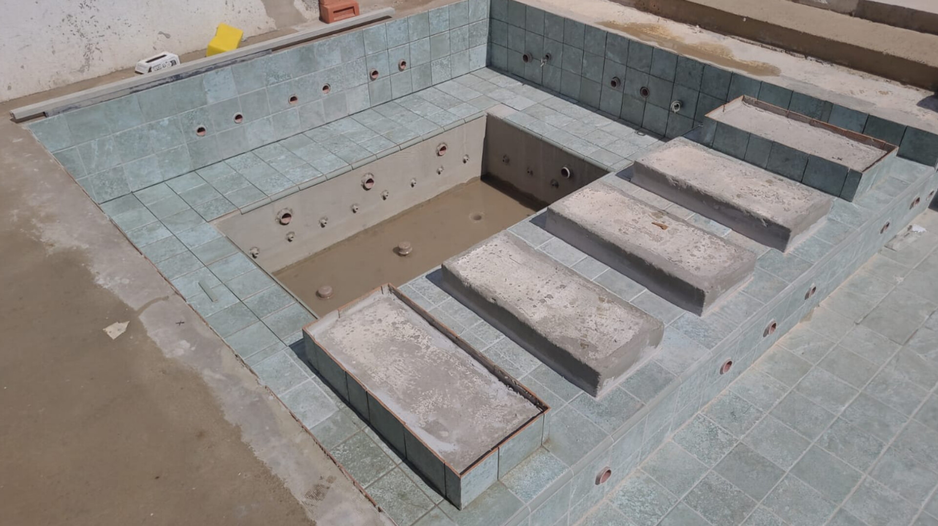Piscina com spa integrado e acabamento em travertino em residência de alto padrão